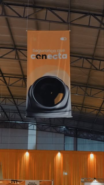 Câmera em frente à comunicação visual do evento AGL Conecta